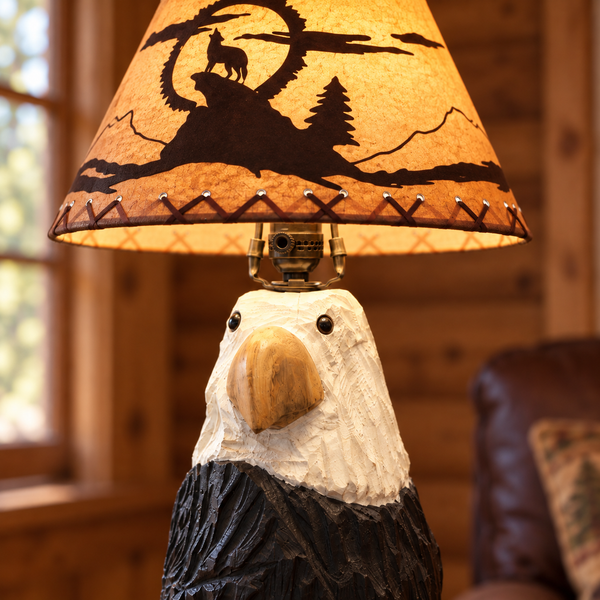 Close-up of the carved eagle face and illuminated wolf woodland lampshade