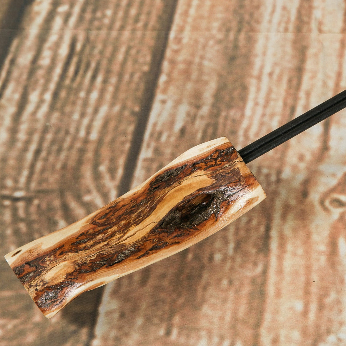 A close-up of a mini roasting fork with a diamond willow handle