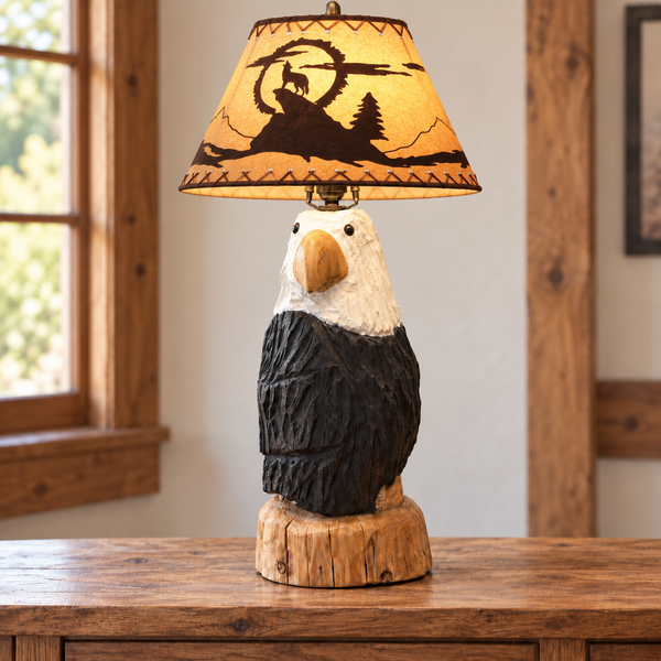 Hand-carved bald eagle lamp glowing on a wood table in a warm rustic cabin setting