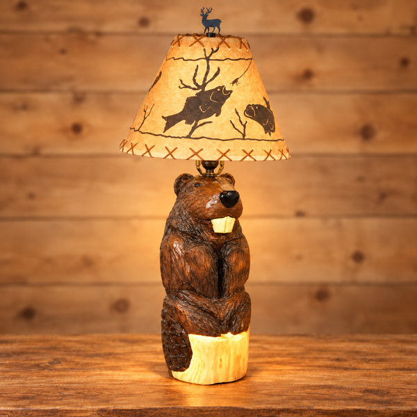 Front view of a handmade chainsaw-carved wooden beaver table lamp with a glowing wildlife shade